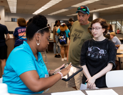 Peer Mentors work with parents and students in Library