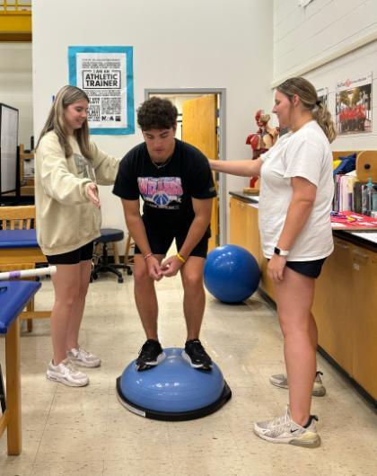 Students working with a Bosu ball in KINS 298