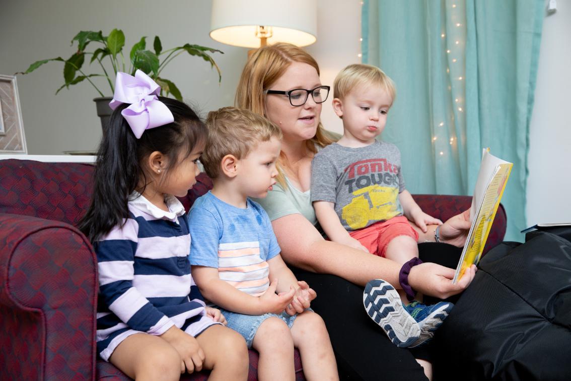 Teacher reading to three children at the Andy Taylor Center