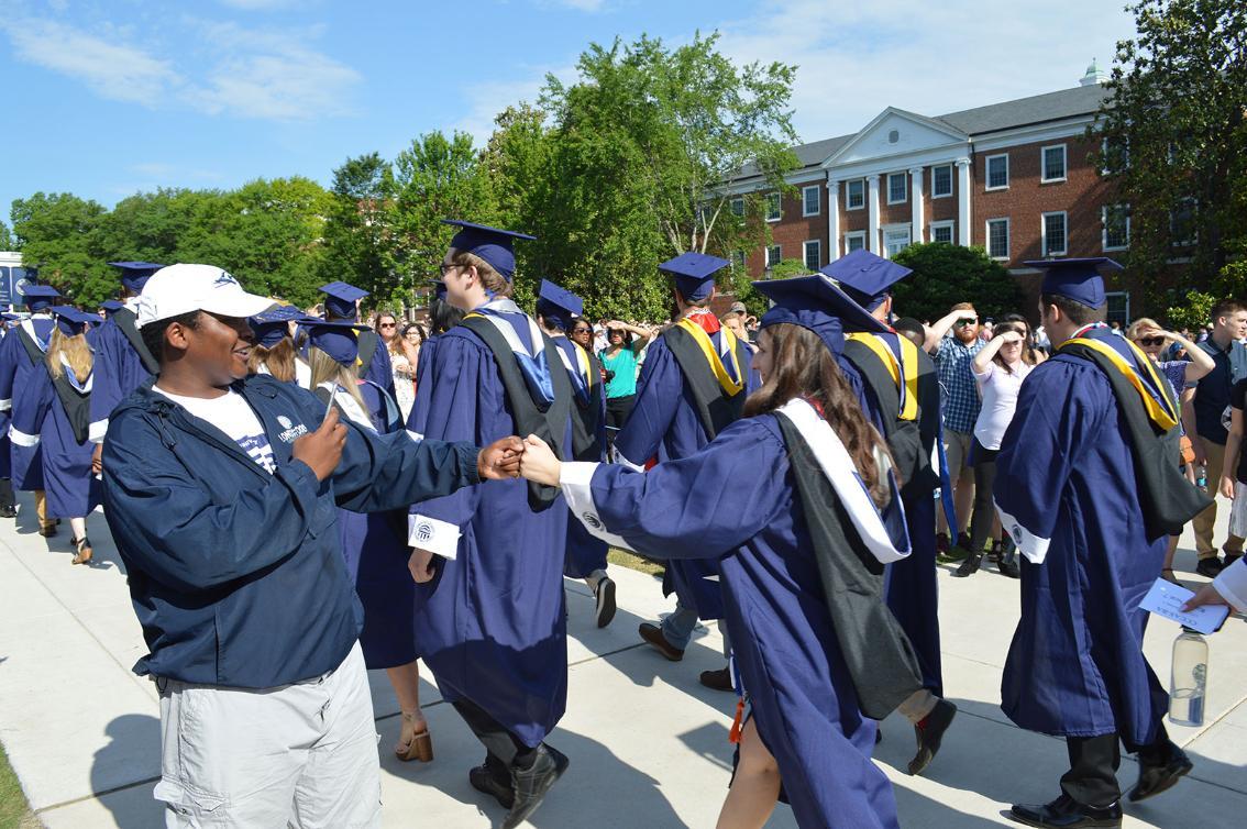 Javion Peterson ’21 hands out fist bumps to graduates