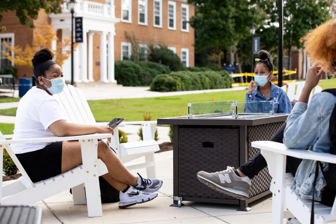 Students sitting around a firepit oustide Upchurch Student Center