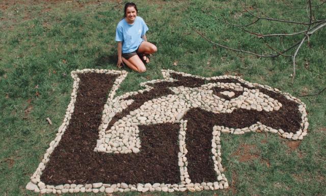 Rachel Arrington ’22 with her rock sculpture of the Lancer logo